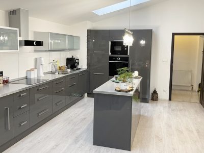 Konfido-Nova-Dedinka-7-izbovy-rodinny-dom-dvojgeneracny-pohlad-od-vstupu-na-terasu-na-krasnu-a-priestrannu-zariadenu-kuchynu-podkrovneho-bytu